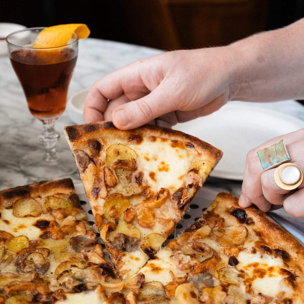 holding a slice of pizza