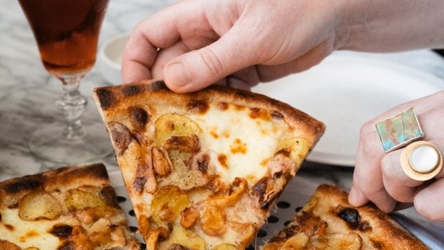 holding a slice of pizza